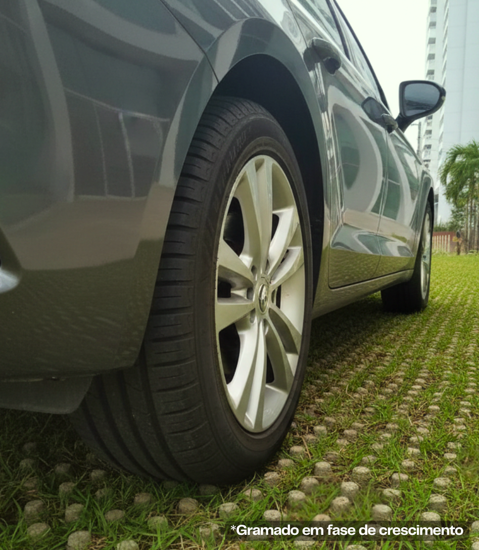 Carro estacionado sobre área externa revestida com Cobograma e gramado em crescimento